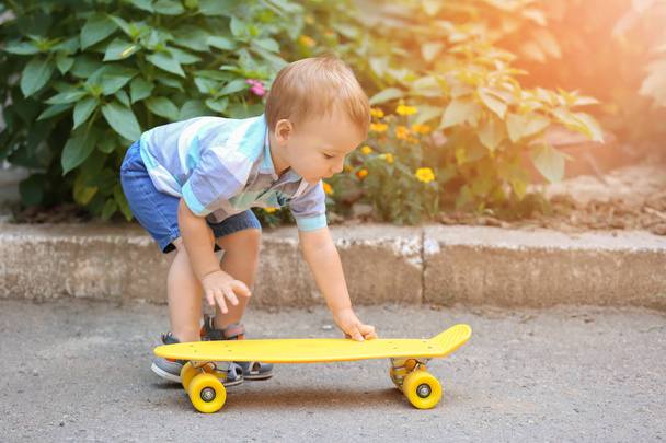 Cute little boy with skateboard outdoors - Фото, зображення