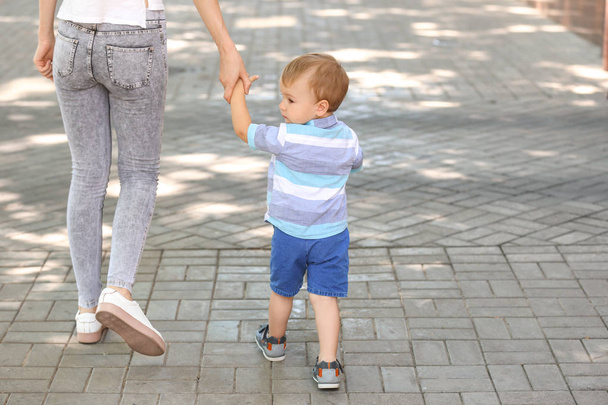 Bonito menino andando com sua mãe ao ar livre
 - Foto, Imagem