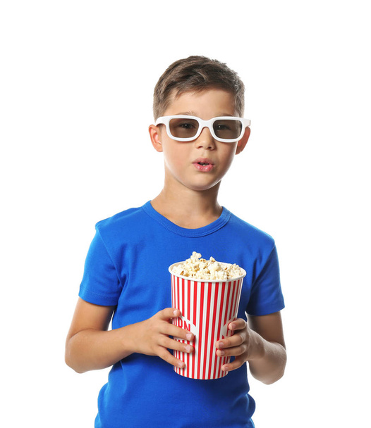 Cute little boy with cup of popcorn watching movie on white background - Foto, Bild