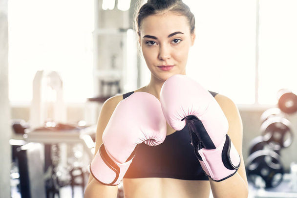 Boxing young beautiful woman exercises with pink glove.She  doing exercise and punching . - Photo, Image