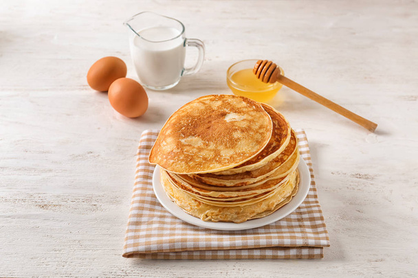 Plate with stack of tasty thin pancakes on table - Photo, Image