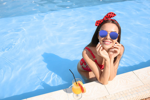 Kaunis nuori nainen cocktail uima-altaassa kesäpäivänä
 - Valokuva, kuva
