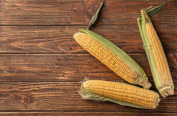 Fresh corn cobs on wooden background - Φωτογραφία, εικόνα