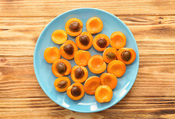Placa con albaricoques dulces maduros sobre mesa de madera
 - Foto, Imagen