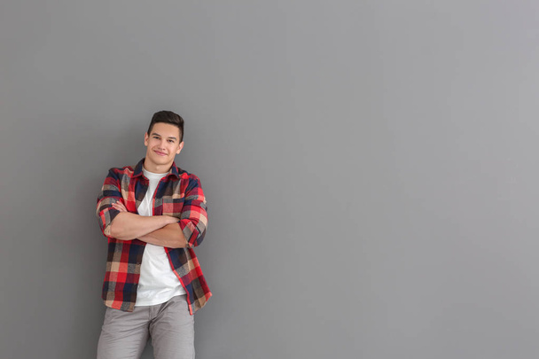 Portrait of handsome young man in casual clothes on grey background - Фото, изображение