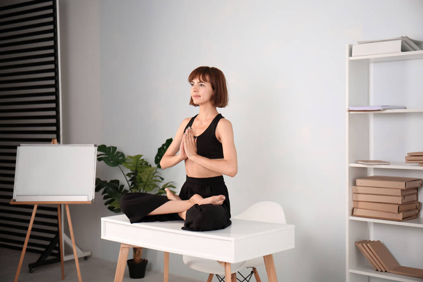 Sportieve vrouw die thuis yoga beoefent - Foto, afbeelding