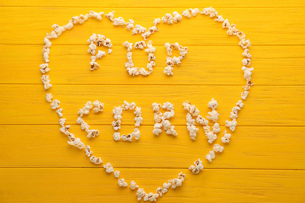 Corazón y palabras hechas de deliciosas palomitas de maíz sobre fondo de madera
 - Foto, Imagen