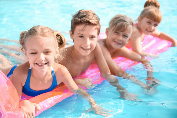 Милые дети плавают в бассейне в летний день
 - Фото, изображение