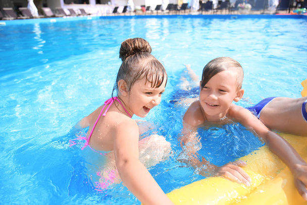 Cute children swimming in pool on summer day - Photo, Image
