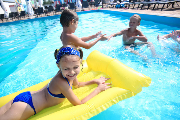 Lindos niños jugando en la piscina en el día de verano
 - Foto, Imagen