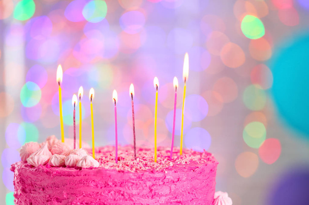 Delicioso pastel de cumpleaños y velas encendidas contra luces borrosas, primer plano
 - Foto, imagen
