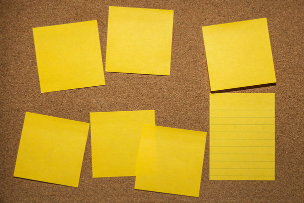yellow reminder sticky note on cork board, empty space for text - Foto, afbeelding