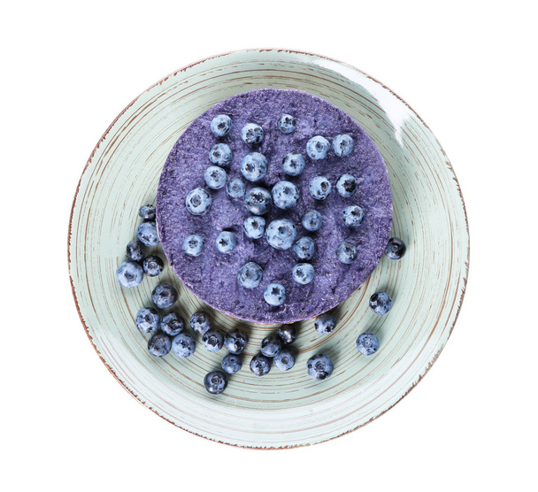 Plate with delicious blueberry cheesecake on white background, top view - Photo, Image