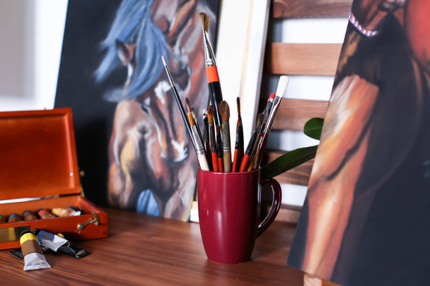 Fotos e ferramentas na mesa na oficina do artista
 - Foto, Imagem