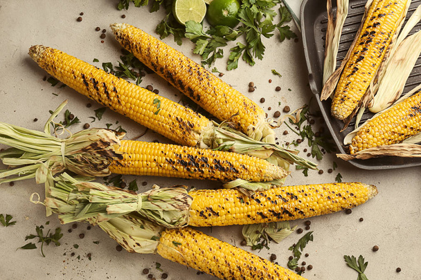 Tasty grilled corn cobs on grey table - Zdjęcie, obraz