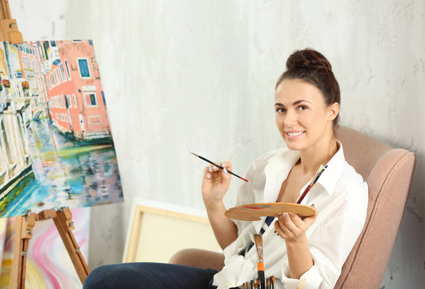 Γυναίκα καλλιτέχνης ζωγραφική εικόνα στο εργαστήριο - Φωτογραφία, εικόνα