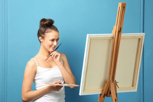 Female artist waiting for inspiration on color background - Photo, Image