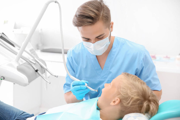 Дантист осматривает зубы маленького мальчика в клинике - Фото, изображение