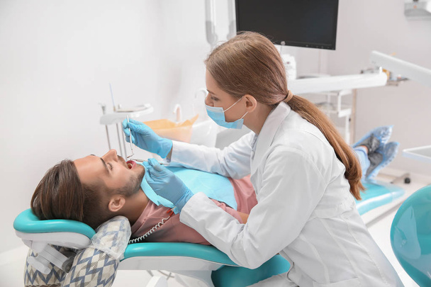 Dentist examining patient's teeth in clinic - Photo, image