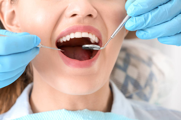 Стоматолог, осматривающий зубы пациента в клинике, крупный план
 - Фото, изображение