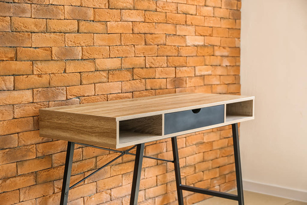 Table near brick wall - Фото, изображение