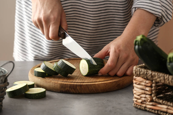 Donna che taglia zucchine in cucina
 - Foto, immagini
