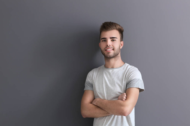 Portrait of handsome young man on grey background - Foto, Imagem