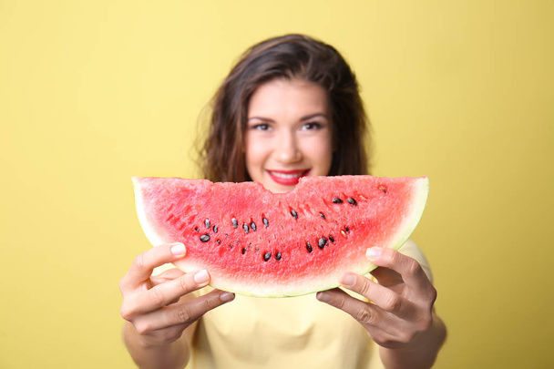 Güzel genç kadın lezzetli karpuz renk arka plan üzerinde dilim ile - Fotoğraf, Görsel