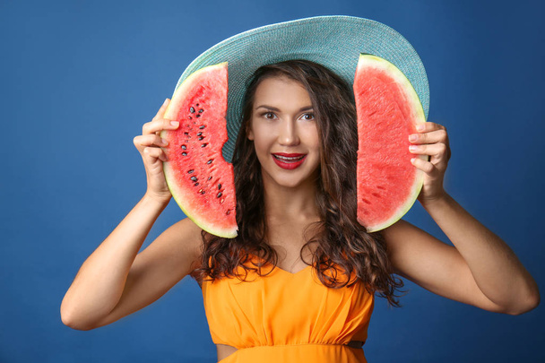 Kaunis nuori nainen viipaleita maukas vesimeloni värillinen tausta
 - Valokuva, kuva