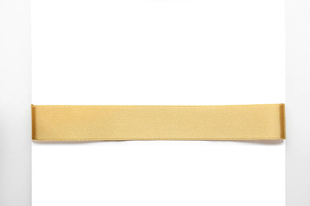 Beautiful golden ribbon with blank card on white background - Photo, Image