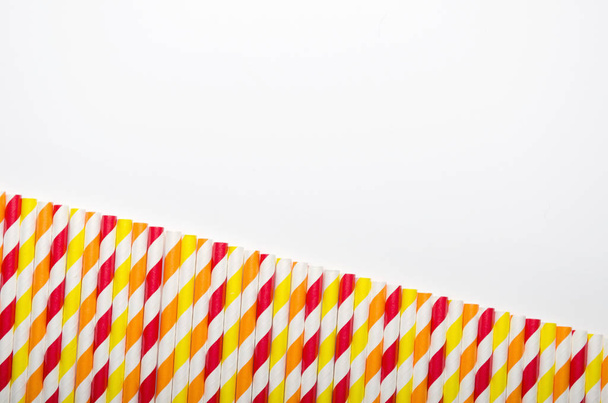 Paille de jus multicolore en rangée sur fond blanc. espace de copie, vue du dessus
 - Photo, image