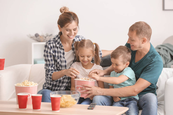 Famiglia mangiare popcorn mentre si guarda la TV a casa
 - Foto, immagini