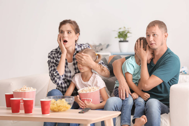 Familie popcorn eten tijdens het kijken naar enge film thuis - Foto, afbeelding