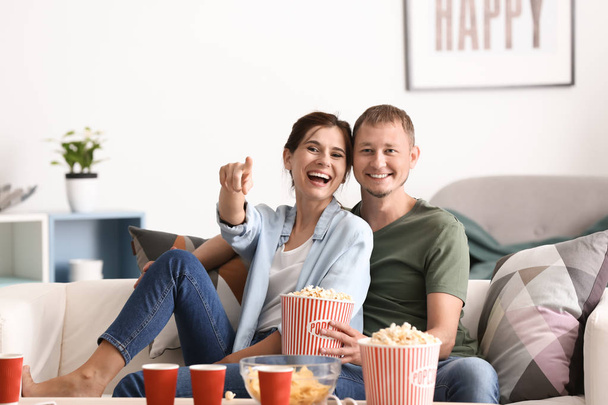 Coppia mangiare popcorn mentre si guarda la TV a casa
 - Foto, immagini