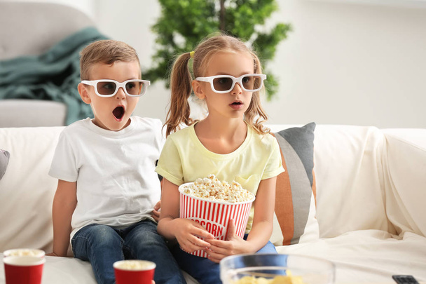 Cute children eating popcorn while watching TV at home - Foto, Imagen