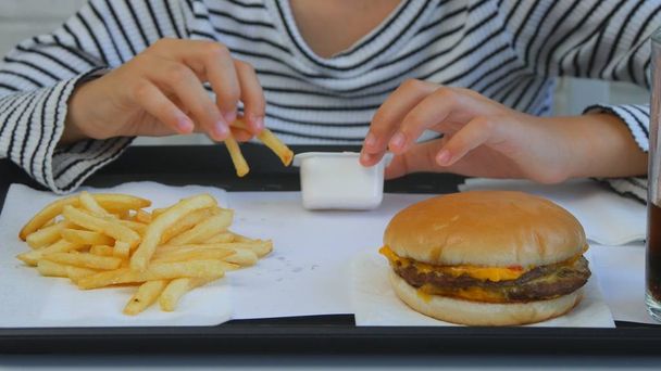 Child Eating Hamburger in Restaurant, Kid Eats Junk Fast Food, Girl Taste Fries - Foto, Bild