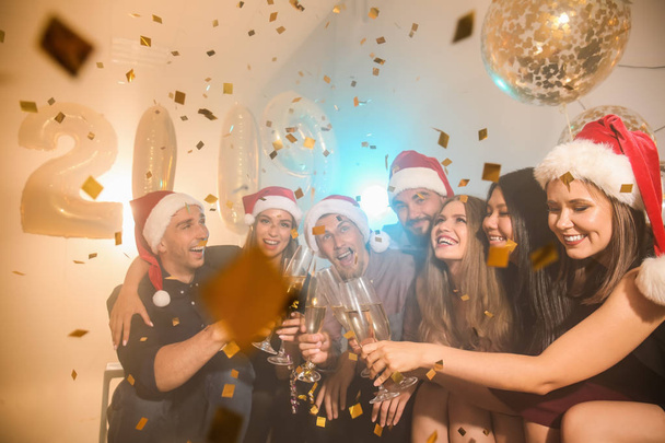 クリスマス パーティーにシャンパンのグラスを持つ若い人々 - 写真・画像