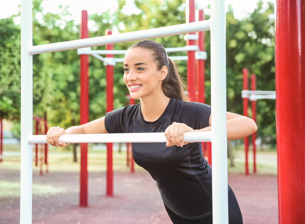 Sportliche junge Frau trainiert auf Sportplatz im Freien - Foto, Bild