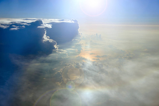 Maravillosa vista desde la ventana del avión en el sol de la mañana sobre las nubes. Nubes inusuales iluminadas por rayos de sol. Nubes blancas sobre fondo azul del cielo. Un sol y un cielo ardientes. Cielo panorama
 - Foto, Imagen