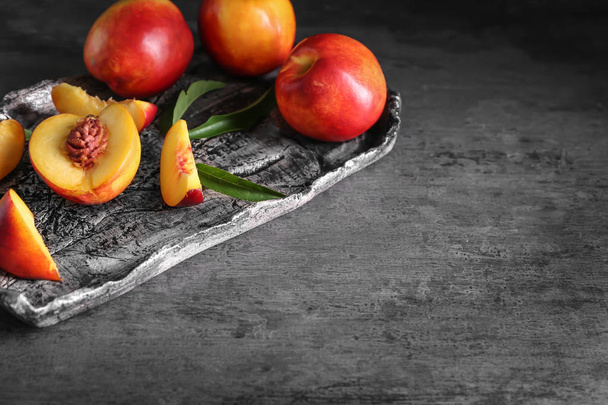 Поднос со свежими персиками на столе
 - Фото, изображение