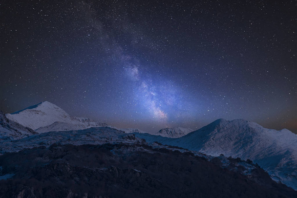 Stunning vibrant Milky Way composite image over landscape of Mount Snowdon and other peaks in Snowdonia National Park - Fotografie, Obrázek
