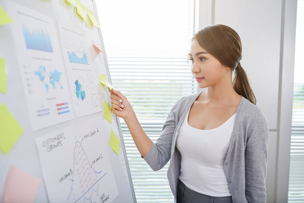 Asian young business woman sticking notes on white board - Photo, Image