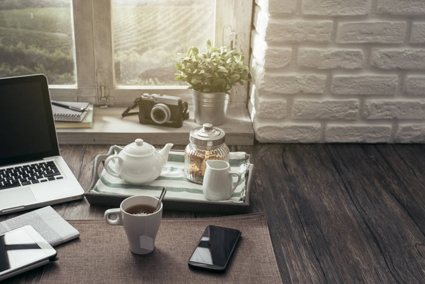 Healthy relaxing breakfast at home on a rustic wooden table with laptop and smartphone - 写真・画像