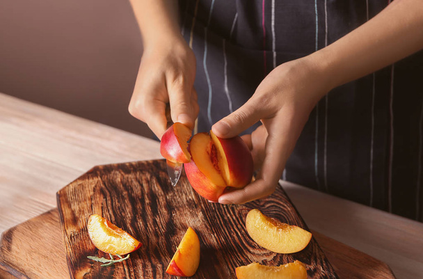 Woman cutting fresh sweet peaches, closeup - Photo, Image