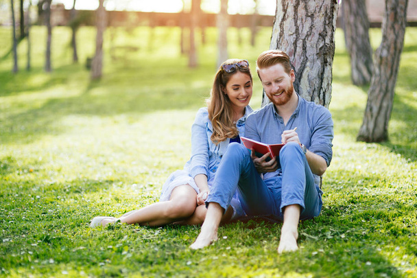 Beautiful couple studying together for exams in nature - Foto, afbeelding