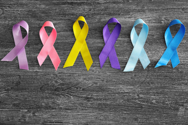 Different ribbons on wooden background. Cancer awareness concept - Photo, Image