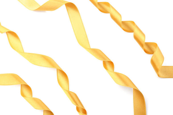 Золотые атласные ленты на белом фоне
 - Фото, изображение