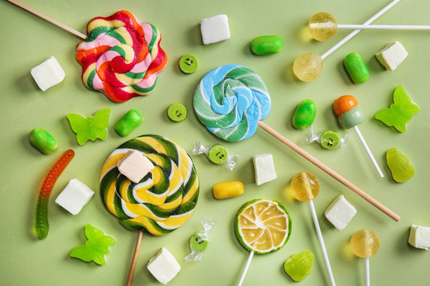 Deliciosas piruletas y dulces sobre fondo de color
 - Foto, Imagen