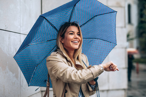 Close up portrait of a young woman with an umbrella outdoors. - Fotó, kép