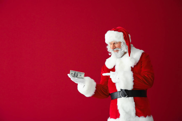 Santa Claus con billetes de dólar sobre fondo de color
 - Foto, Imagen